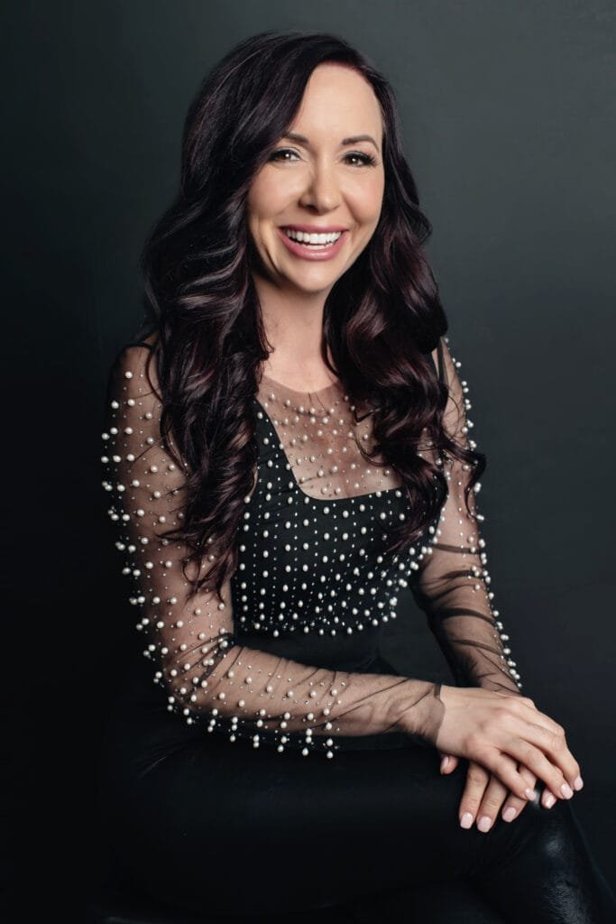 Smiling woman in pearl-embellished top, MyBioGlow founder professional headshot.