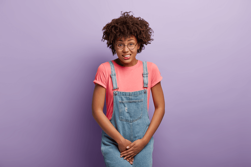 Young woman showing urinary discomfort, related to pelvic wellness services at MyBioGlow.